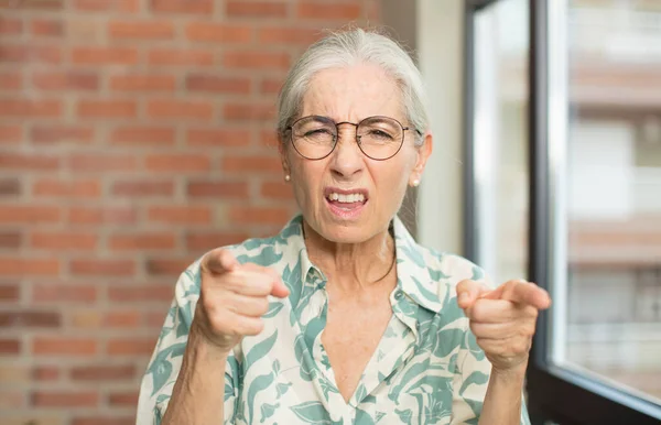 指と怒りの表情でカメラを前に向ける年配の女性が — ストック写真