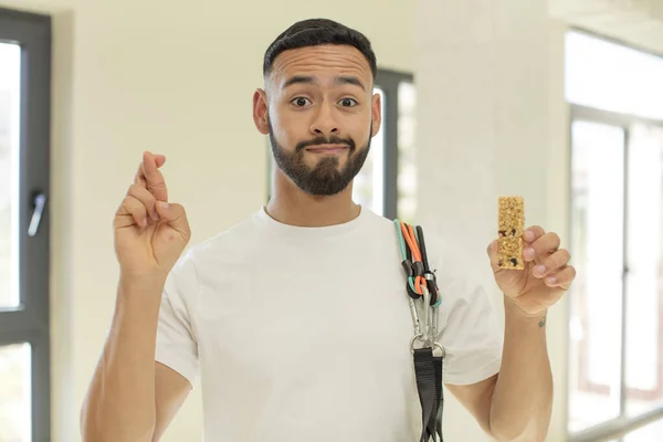 arab handsome man arab man crossing fingers and hoping for good luck.  fitness and cereal bar concept