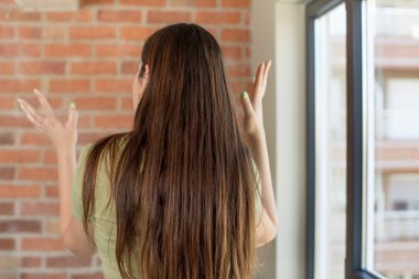 Genç ve güzel bir kadın ellerini havaya kaldırmış öfkeli, sinirli, stresli ve üzgün.