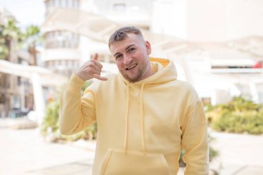 Yakışıklı adam mutlu ve neşeyle el sallıyor, seni selamlıyor ya da veda ediyor.