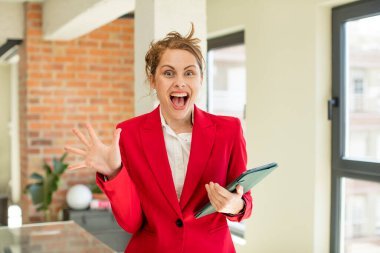 Genç ve güzel bir kadın inanılmaz bir şey karşısında kendini mutlu ve şaşkın hissediyor. Dokunmatik ekran konsepti