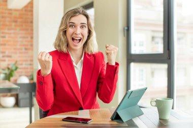 Güzel kadın şokta, gülüyor ve başarıyı kutluyor. dokunmatik ekran konsepti