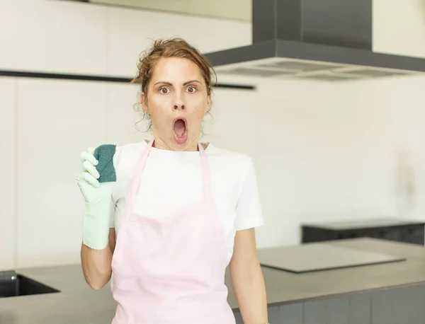 Young Pretty Woman Feeling Extremely Shocked Surprised Housekeeper Concept — Stockfoto