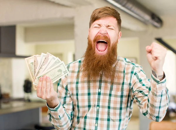 红头发的男人满脸怒容 对美元钞票感到恼怒和沮丧 — 图库照片