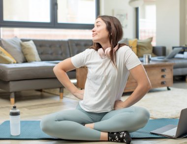 Genç yetişkin bir kadın yoga yapıyor. Mutlu düşünceler ve fikirler düşünüyor. Hayal kuruyor.