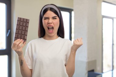 Güzel, genç bir kadın sinirli, sinirli ve sinirli görünüyor. çikolata kavramı