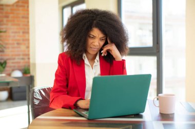 Oldukça afro siyahi bir kadın şaşırmış görünüyor, yeni bir düşünce, fikir ya da konsept fark ediyor. iş kadını ve dizüstü bilgisayar konsepti