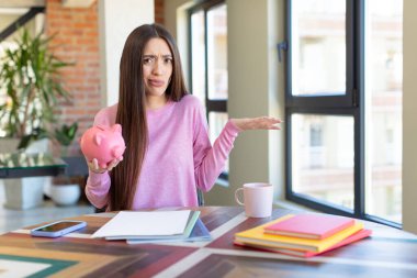 Omuz silkmek, kafası karışık ve kararsız hissetmek. Domuz kumbarası konsepti