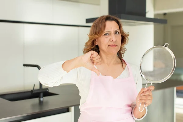 Middle Age Pretty Woman Feeling Cross Showing Thumbs Cooking Home — Stock Photo, Image