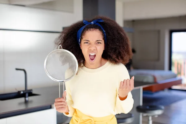 pretty afro black woman looking angry, annoyed and frustrated. home chef concept
