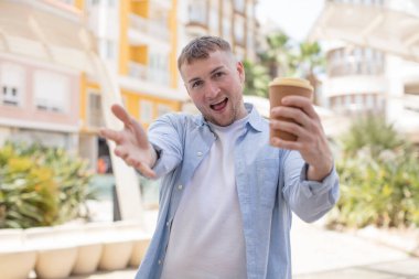 Mutlu bir şekilde gülümsemek ve bir konsept sunmak veya göstermek. Kahveyi götür.