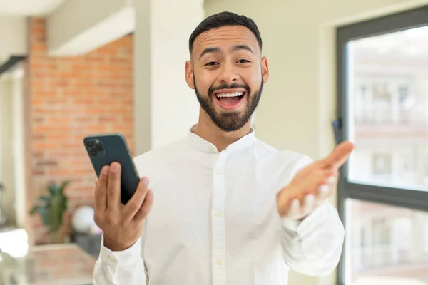 Young Adult Man Smiling Happily Offering Showing Concept Smartphone Concept — Stock Photo, Image
