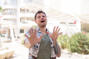 Yakışıklı adam korkmuş hissediyor, korku ve panik içinde geri çekiliyor ve bir kabusa tepki veriyor.