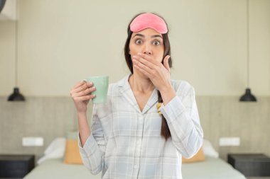 Ağzı kaplayan genç ve güzel bir manken. Şok olmuş ya da şaşırmış bir ifade. dinlenme ve gecelik konsepti