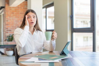 Genç ve güzel bir kadın mutlu, şaşkın ve şaşırmış görünüyor. Evden işe dolaşma kavramı