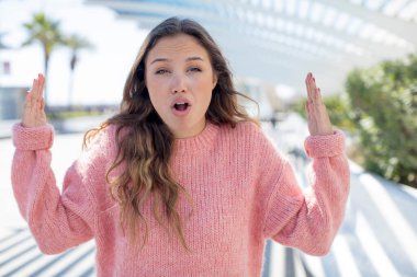 Güzel İspanyol bir kadın iki eliyle bir nesneyi tutuyor, bir nesneyi gösteriyor, sunuyor ya da reklamını yapıyor.