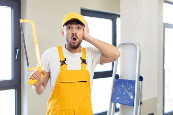 Young Handsome Man Feeling Extremely Shocked Surprised Handyman Saw — Stock Photo, Image