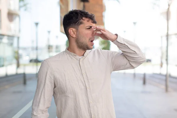 Mladý Pohledný Muž Cítí Znechucen Drží Nos Aby Neucítil Odporný — Stock fotografie
