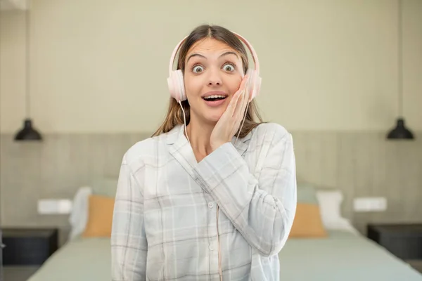 若い可愛い女は何か信じられないほどの幸せと驚きを感じる ヘッドフォンのコンセプト — ストック写真
