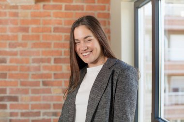 young adult pretty woman with a big, friendly, carefree smile, looking positive, relaxed and happy, chilling