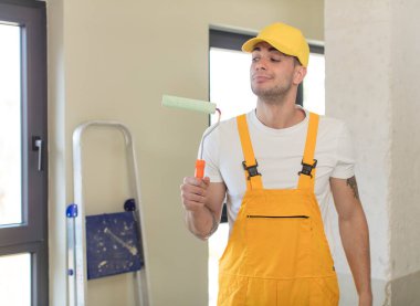 Genç ve yakışıklı bir adam gülümsüyor ve kendine güveni tam bir ifadeyle bakıyor. resim ev kavramı