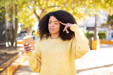 Oldukça afro siyahi bir kadın şaşırmış görünüyor, yeni bir düşünce, fikir ya da konsept fark ediyor. kahve konseptini kaldır.