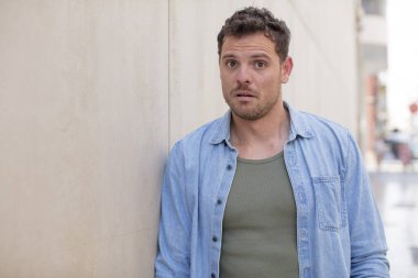 Yakışıklı adam korkmuş ve şok olmuş hissediyor, ağzı açık şaşkınlık içinde.