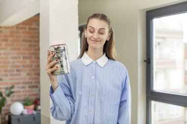 Gülümsüyor ve mutlu ve kendinden emin bir ifadeyle bakıyor. Dolar banknotları konsepti