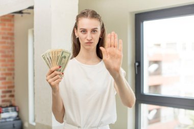 Avuç içinin açık durduğunu gösteren ciddi bir hareket. Dolar banknotları konsepti