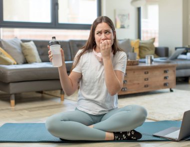 Genç, güzel bir kadın korkmuş, endişeli ya da kızgın hissediyor ve yan tarafa bakıyor. yoga konsepti