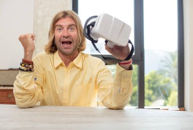 Genç, beyaz bir adam şokta, gülüyor ve başarıyı kutluyor. sanal gözlük konsepti