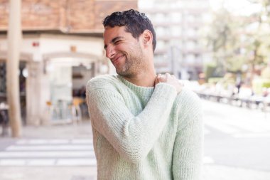 Genç İspanyol adam yorgun, stresli, endişeli, hayal kırıklığına uğramış ve depresif hissediyor. Sırtı ya da boynu ağrıyormuş.
