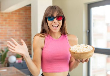 Genç ve güzel bir kadın inanılmaz bir şey karşısında kendini mutlu ve şaşkın hissediyor. patlamış mısır film konsepti