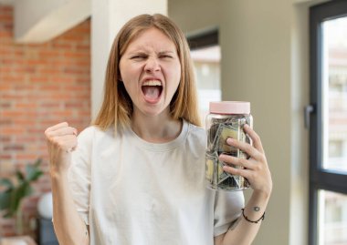 Genç ve güzel bir kadın sinirli, sinirli ve sinirli görünüyor. Dolar banknotları konsepti