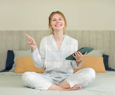 Genç, güzel bir kadın neşeyle gülümsüyor, mutlu hissediyor ve bir tarafı işaret ediyor. gece kıyafeti konsepti