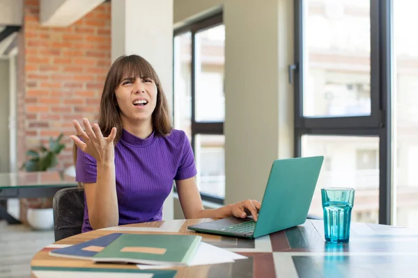 stock image young pretty woman screaming with hands up in the air.  universitary student with a laptop