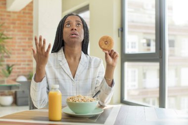 Siyah afro kadın ellerini havaya kaldırarak çığlık atıyor. kahvaltı kavramı