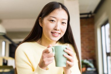 asian pretty woman with a coffee cup at cool home