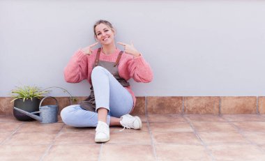 Kendi geniş gülüşüne, pozitif, rahat, tatmin olmuş tavrına güvenerek gülümsüyor. gardering konsepti