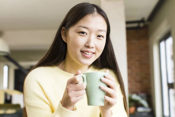 涼しい家でコーヒーカップを持つアジア系の可愛い女性 — ストック写真