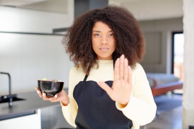 Güzel afro siyahi kadın ciddi görünüyor. Avuç içini gösteriyor. Durdurma hareketi yapıyor. Japon eriştesi kavramı.