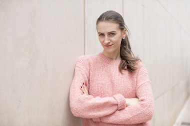 Güzel bir kadın hayal kırıklığına uğramış, hayal kırıklığına uğramış, ciddi görünüyor, kızgın ve kollarını kavuşturmuş.