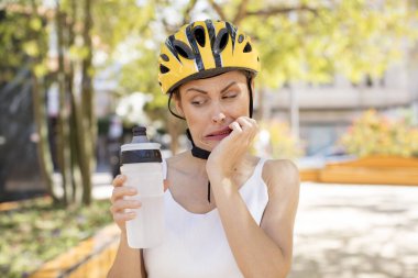 Genç, güzel bir kadın korkmuş, endişeli ya da kızgın hissediyor ve yan tarafa bakıyor. bisiklet kaskı konsepti