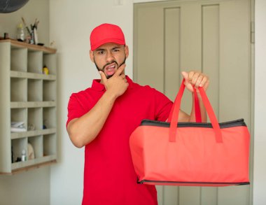 Ağzı ve gözleri açık ve eli çenesinde olan genç bir adam. Pizza teslimatçısı konsepti