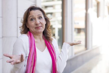 Orta yaşlı kadın şaşkın ve şaşkın hissediyor, şüpheci, ağırlıklı ya da farklı seçenekler seçiyor