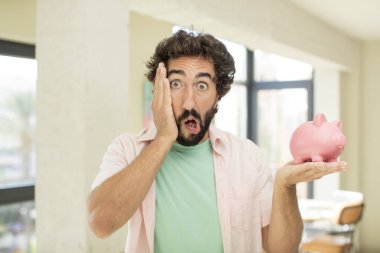 Çılgın sakallı adam şok olmuş ve şaşırmış hissediyor. Domuz kumbarası konsepti