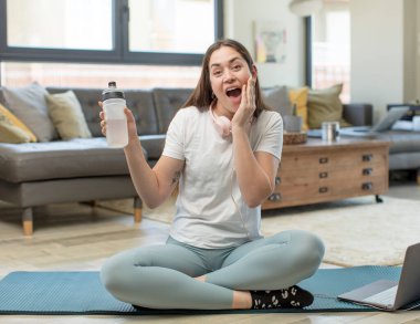 Genç ve güzel bir kadın inanılmaz bir şey karşısında kendini mutlu ve şaşkın hissediyor. yoga konsepti