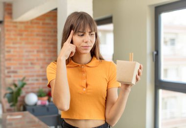 Genç, güzel bir kadın şaşırmış görünüyor, yeni bir düşünce, fikir ya da konsept fark ediyor. Ramen kasesi erişte konsepti