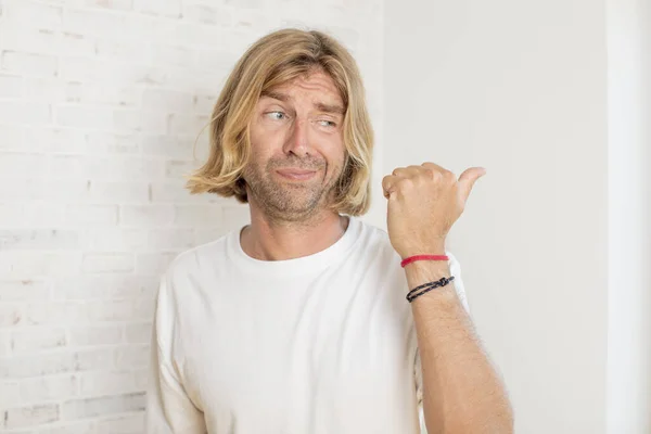 stock image young blond adult man worried, feeling scared, frustrated and stressed