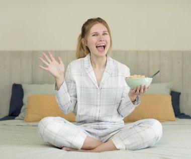 Genç ve güzel bir kadın inanılmaz bir şey karşısında kendini mutlu ve şaşkın hissediyor. Kahvaltı kasesi konsepti